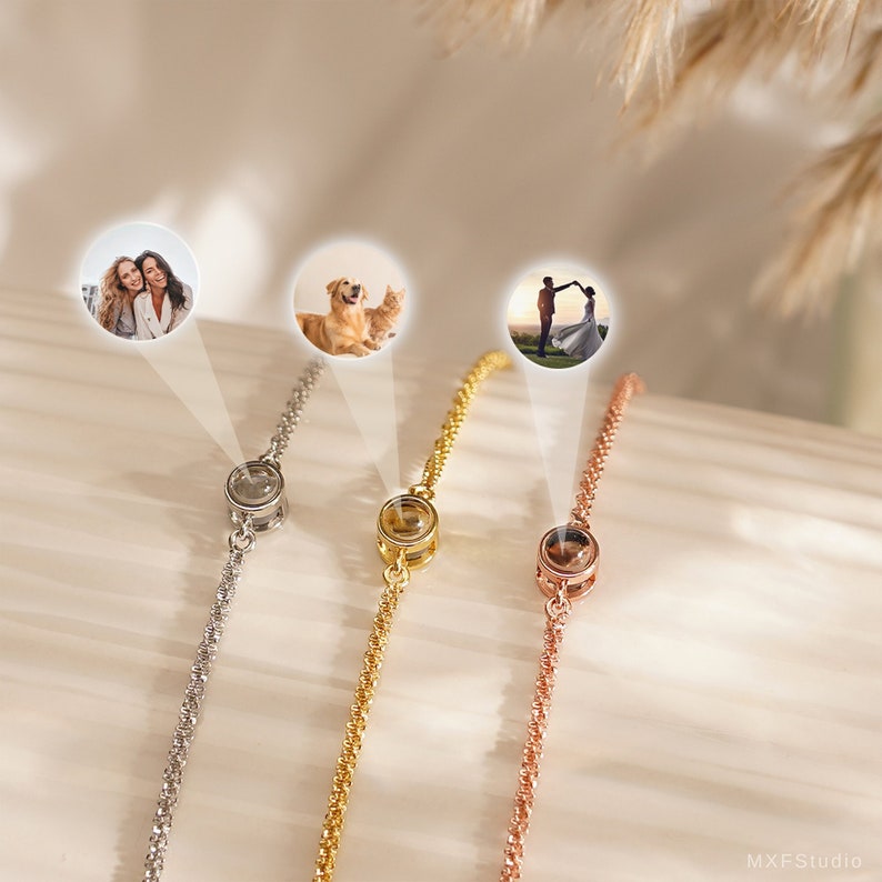 May include: Three silver, gold, and rose gold bracelets with a small round charm that can hold a photo. The charms are clear and have a small silver ring around the edge. The bracelets are delicate and dainty.