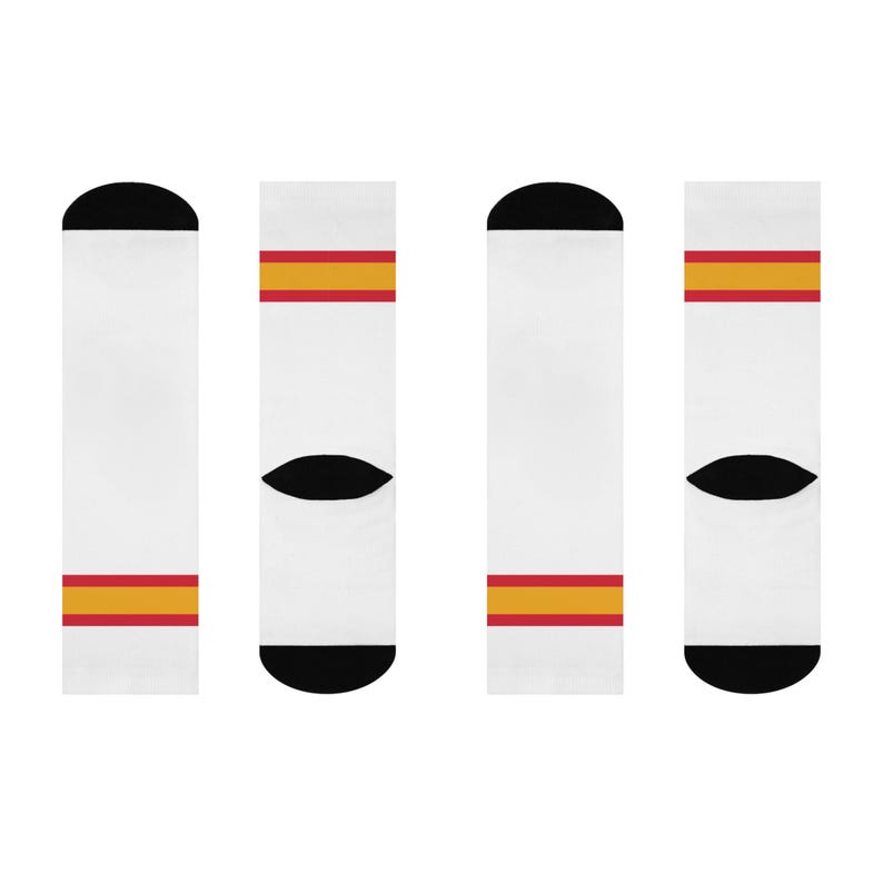 May include: Four pairs of white socks with red and yellow stripes. The socks have a black toe and heel.