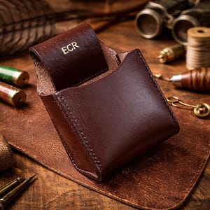 Estuche de cuero con iniciales en relieve para cartuchos de escopeta, con trabilla para cinturón, ideal como regalo de tiro.