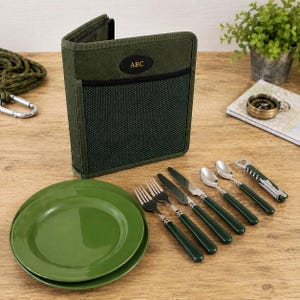 Puede incluir: Un estuche de tela verde oliva oscuro con un bolsillo de malla negra y un parche ovalado con la etiqueta ABC. El juego incluye dos platos verdes a juego, dos tenedores, dos cuchillos, dos cucharas y un sacacorchos con mangos verdes.