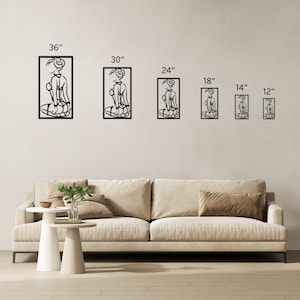 Puede incluir: Un conjunto de seis piezas de arte de pared de metal negro que presentan una figura estilizada en varios tama&ntilde;os, que van desde 30 cm hasta 91 cm. Las piezas de arte se muestran en una pared blanca con un sof&aacute; beige en primer plano.
