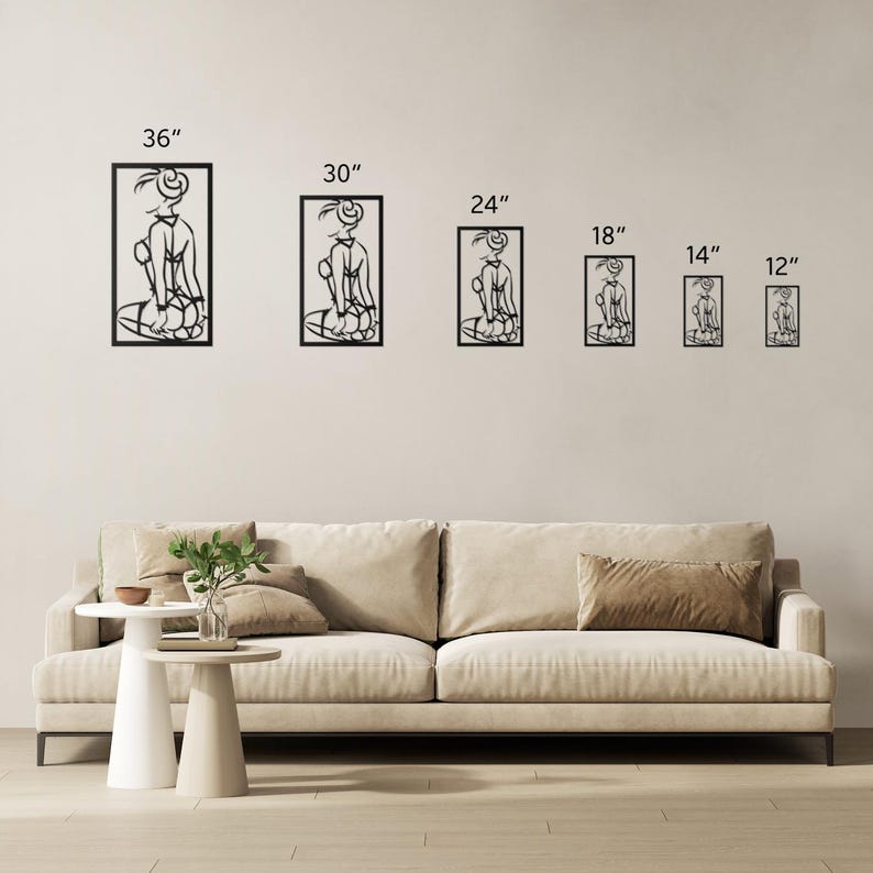 Puede incluir: Un conjunto de seis piezas de arte de pared de metal negro que presentan una figura estilizada en varios tama&ntilde;os, que van desde 30 cm hasta 91 cm. Las piezas de arte se muestran en una pared blanca con un sof&aacute; beige en primer plano.
