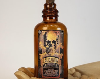 Small antique amber glass pharmacy bottle (empty) with "Laudanum" decorative design