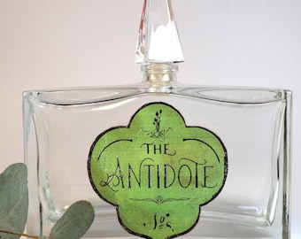 Empty antique glass bottle with decorative label "Antidote"
