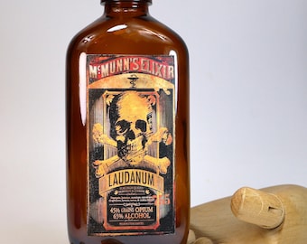 Antique and empty amber glass pharmacy or apothecary bottle with a decorative "Laudanum" label