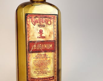 Antique and empty amber glass pharmacy or apothecary bottle with "Poison LAUDANUM" decorative design