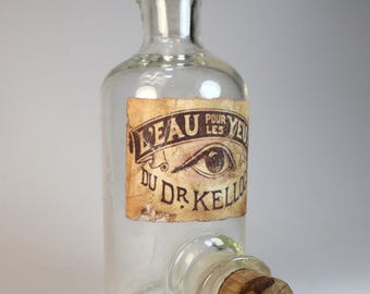 Antique empty glass pharmacy bottle with decorative label "Dr. Kellogg's Eye Water"