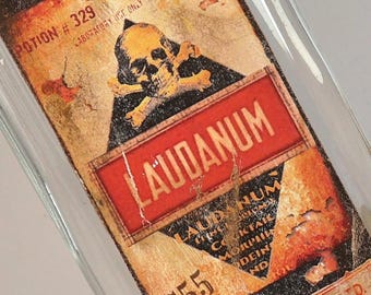 Antique glass pharmacy bottle with decorative label "LAUDANUM"