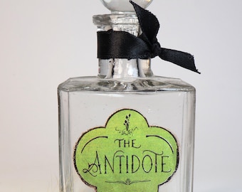 Empty antique glass bottle with decorative label "Antidote"