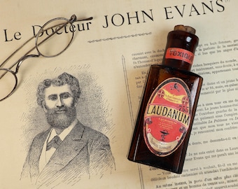 Antique and empty amber glass pharmacy or apothecary bottle with a decorated "Laudanum" label