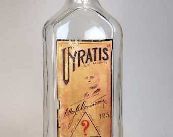 Antique empty glass pharmacy bottle with "Uyratis" decorative label