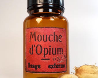 Antique and empty amber glass pharmacy bottle with decorative label design "Opium Fly"