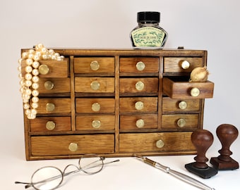 Small vintage wooden watchmaker's cabinet with drawers.