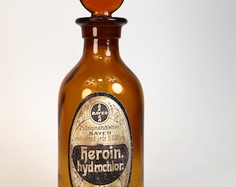 Antique amber glass pharmacy or apothecary bottle, empty, with decorative label creation