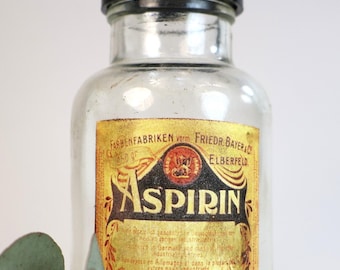 1950s glass jar or bottle (empty), with a decorative label design for "ASPIRIN"