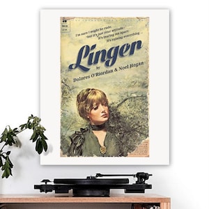 May include: A framed print of a book cover titled "Linger" by Dolores O'Riordan & Noel Hogan. The cover art features a woman with blonde hair and a green dress. The print is displayed on a white background.
