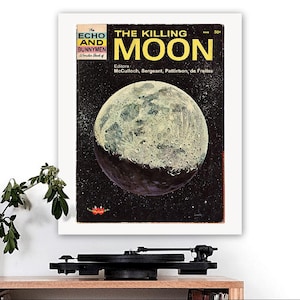 May include: A framed vintage comic book cover titled "The Killing Moon" with a detailed illustration of the moon against a starry backdrop. The cover also includes the text "The Echo and the Bunnymen Wonder Book of".