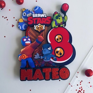 May include: A colorful cake topper featuring characters from "Brawl Stars" with the number 8 and the name "Mateo". The design includes red, blue, and green figures, a red glitter number 8, and the text "Brawl Stars".