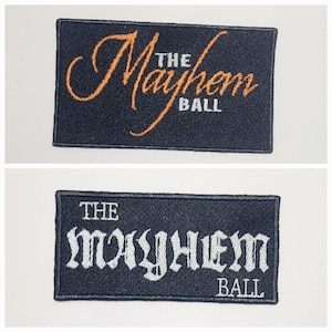 Può includere: Due toppe rettangolari ricamate. La toppa superiore presenta le parole "The Mayhem Ball" in scrittura arancione e lettere bianche su sfondo nero. La toppa inferiore ha lo stesso testo in lettere gotiche bianche.