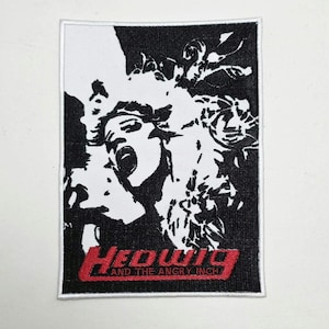 Puede incluir: Parche rectangular con un gráfico en blanco y negro de una persona gritando. La palabra "Hedwig" está en rojo, con texto estilizado, con "AND THE ANGRY INCH" debajo. Borde blanco.