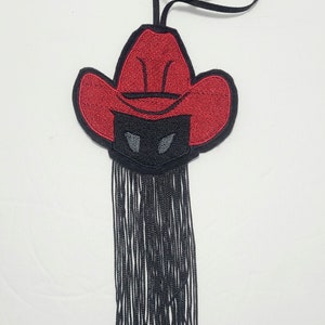 May include: A red cowboy hat with a black face mask and a long black fringe hanging from the bottom.