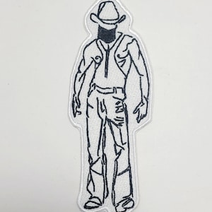May include: Black and white embroidered patch featuring a stylized outline of a person wearing a cowboy hat, vest, and jeans. The patch has a white border and is likely designed to be ironed or sewn onto fabric.
