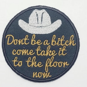 May include: Embroidered patch with a black background and a white cowboy hat design. The patch features gold text that reads "Don't be a bitch come take it to the floor now."