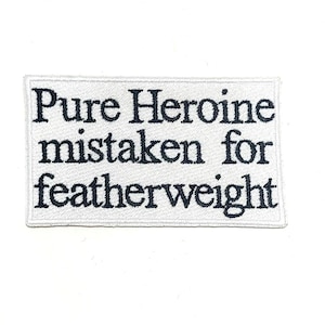 May include: A rectangular white embroidered patch with black text that reads "Pure Heroine mistaken for featherweight". The patch has a white border and is set against a white background.