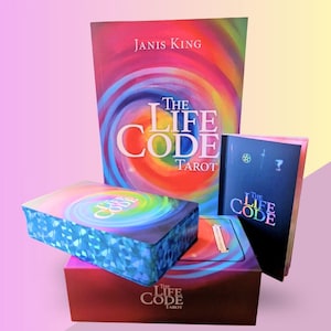 May include: A selection of tarot products, including a book and card decks, with the title "The Life Code Tarot." The book cover displays the author's name, Janis King, and a vibrant spiral design. The card decks have a matching design.
