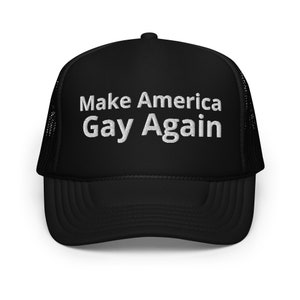 Könnte beinhalten: Schwarze Trucker-Mütze mit weiß gesticktem Text "Make America Gay Again". Die Mütze hat eine Netzrückseite und einen gebogenen Schirm. Der Text ist mittig auf der Vorderseite der Mütze angebracht.