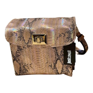 May include: A metallic snakeskin-patterned handbag with a gold-toned clasp. The bag has a flap closure and a detachable strap. A black tag with the text "just cavalli" is attached to the side.