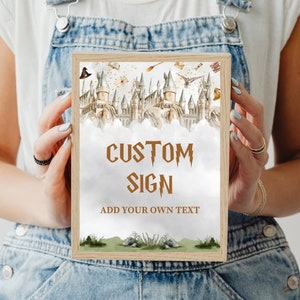 May include: A printable sign with a watercolor illustration of Hogwarts castle. The sign has a brown wooden frame and says "Custom Sign" in brown text with a lightning bolt design. The text "Add your own text" is also included in brown text.