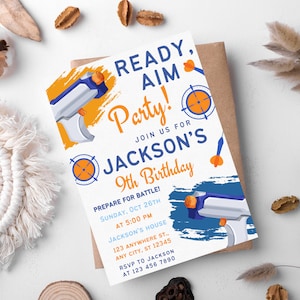 May include: A white birthday party invitation with blue and orange accents. The invitation features a cartoon image of a toy gun and a target. The text reads "Ready, Aim, Party! Join us for Jackson's 9th Birthday! Prepare for Battle! Sunday, Oct 26th at 5:00 PM Jackson's House 123 Anywhere St., Any City, ST 12345 RSVP to Jackson at 123 456 7890".