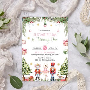 Może przedstawiać: Świąteczne zaproszenie z napisem "OUR LITTLE SUGAR PLUM Is Turning One". Projekt zawiera ilustracje myszy, baletnicy i dziadka do orzechów, a także choinki i pudełka z prezentami. Data to czwartek, 24 października o godzinie 17:00.