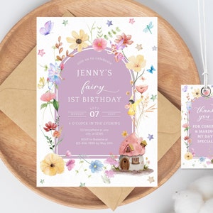May include: A purple and white fairy-themed first birthday party invitation with a watercolor illustration of a fairy house, flowers, and fairies. The text reads "Join us to celebrate Jenny's fairy 1st birthday, Monday Sept 07, 4 o'clock in the evening, 123 anywhere st.ang, city 12345, RSVP to Natasha at 123-456-7890 by May 100%". A matching thank you tag with the same design and the text "Thank you for coming & making my day special" is included.