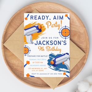 May include: A white invitation card with blue and orange accents. The card features a cartoon image of two toy water guns and a target. The text on the card reads "Ready, Aim Party!" and "Jackson's 9th Birthday".
