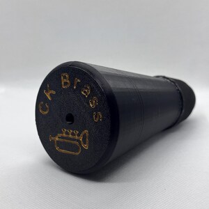 May include: Black trumpet mouthpiece with gold lettering that reads "CK Brass" and a trumpet icon.