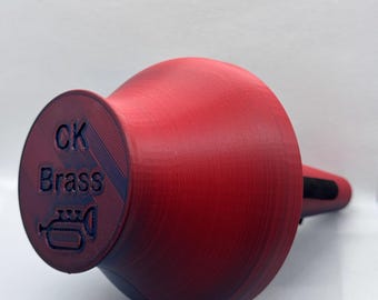 May include: A red trumpet mouthpiece with a black mouthpiece cap. The mouthpiece has the text "CK Brass" and a trumpet icon.