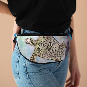 Könnte beinhalten: Eine schwarze Bauchtasche mit einem blauen Reißverschluss und einem farbenfrohen Muster einer Meeresschildkröte auf einem blauen und weißen Aquarellhintergrund.