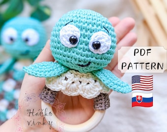 May include: Crocheted turtle rattle toy with a wooden ring. The turtle is light blue with white eyes and a brown mouth. The rattle is a great baby toy.