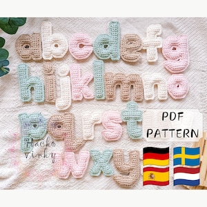 Peut inclure: Lettres de l'alphabet en crochet de différentes couleurs pastel, dont le rose, le vert et le marron. Les lettres sont disposées en ordre alphabétique et sont affichées sur un fond en tissu blanc. Le texte "PDF PATTERN" est affiché en noir sur fond blanc. Les drapeaux de l'Allemagne, de l'Espagne et de la Suède sont affichés dans le coin inférieur droit de l'image.