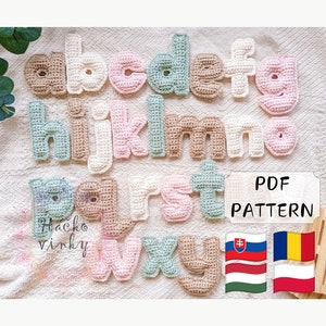 Peut inclure: Lettres de l'alphabet en crochet de différentes couleurs, dont le beige, le rose, le blanc et le vert. Les lettres sont disposées en ordre alphabétique et sont affichées sur un fond en tissu blanc. Le texte "PDF PATTERN" est visible sur l'image.