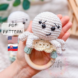 May include: Crochet octopus rattle toy with a wooden ring. The octopus is white with black eyes and a smiling mouth. The octopus is wearing a yellow and green crocheted skirt. The toy is handmade and is perfect for babies.