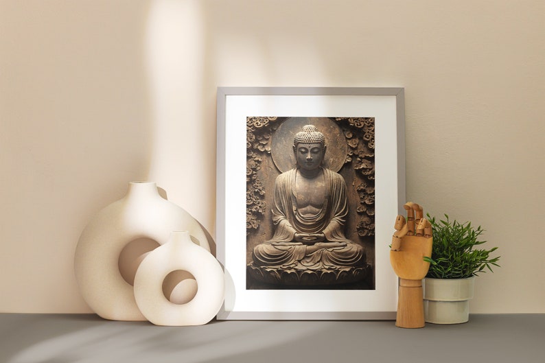 May include: A framed print of a brown Buddha statue sitting in a meditative pose. The statue is surrounded by a carved floral design. The print is displayed on a shelf with two white ceramic vases and a wooden hand sculpture.