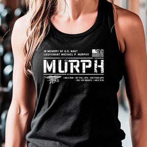 May include: Black tank top with a white graphic that says "MURPH" in memory of U.S. Navy Lieutenant Michael P. Murphy. The graphic also includes the text "1 mile run - 100 pull ups - 200 push ups - 300 air squats - 1 mile run".