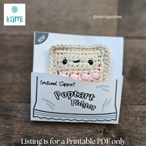 May include: A crocheted Poptart Fidget toy with a smiling face, presented in a white box labeled "Emotional Support." The toy is beige with pink accents and the box reads "Poptart Fidget." The image also includes the text "Listing is for a Printable PDF only."