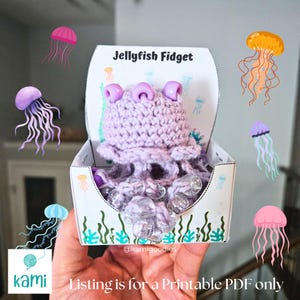 May include: A handmade lavender crochet jellyfish fidget toy in a decorative box. The box is labeled "Jellyfish Fidget" and features illustrations of jellyfish. The toy is filled with clear beads. The text "Listing is for a Printable PDF only" is visible.