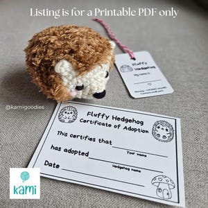 May include: A handmade, fluffy hedgehog toy with brown and cream yarn. It has a black nose and pink cheeks. Included is a certificate of adoption and a tag that reads "Fluffy Hedgehog". The text "Listing is for a Printable PDF only" is also visible.