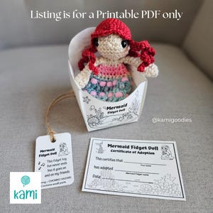 May include: A handmade crochet mermaid doll with red hair and a colorful dress, presented in a decorative box. The box and a tag read "Mermaid Fidget Doll". A certificate of adoption is also included. The text "Listing is for a Printable PDF only" is at the top.