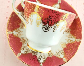 Xícara de chá Paragon, fabricada na Inglaterra, rosa e dourada, com flores e frutos silvestres, certificado pela Casa Real Britânica, década de 1960.